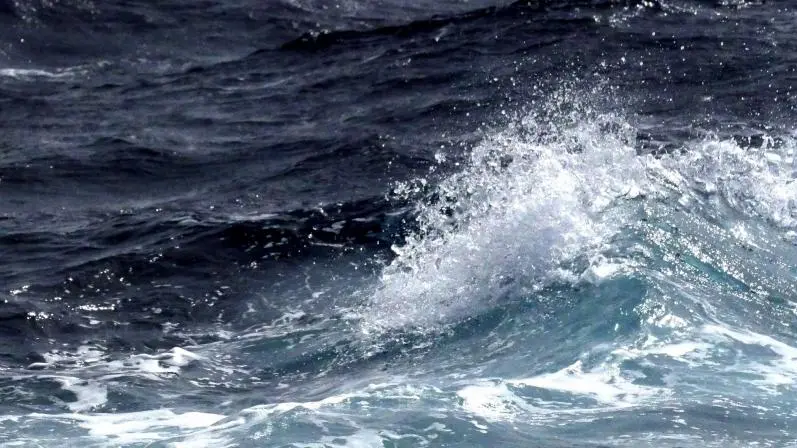 Vista de la superficie del océano con oleaje, olas y espuma.