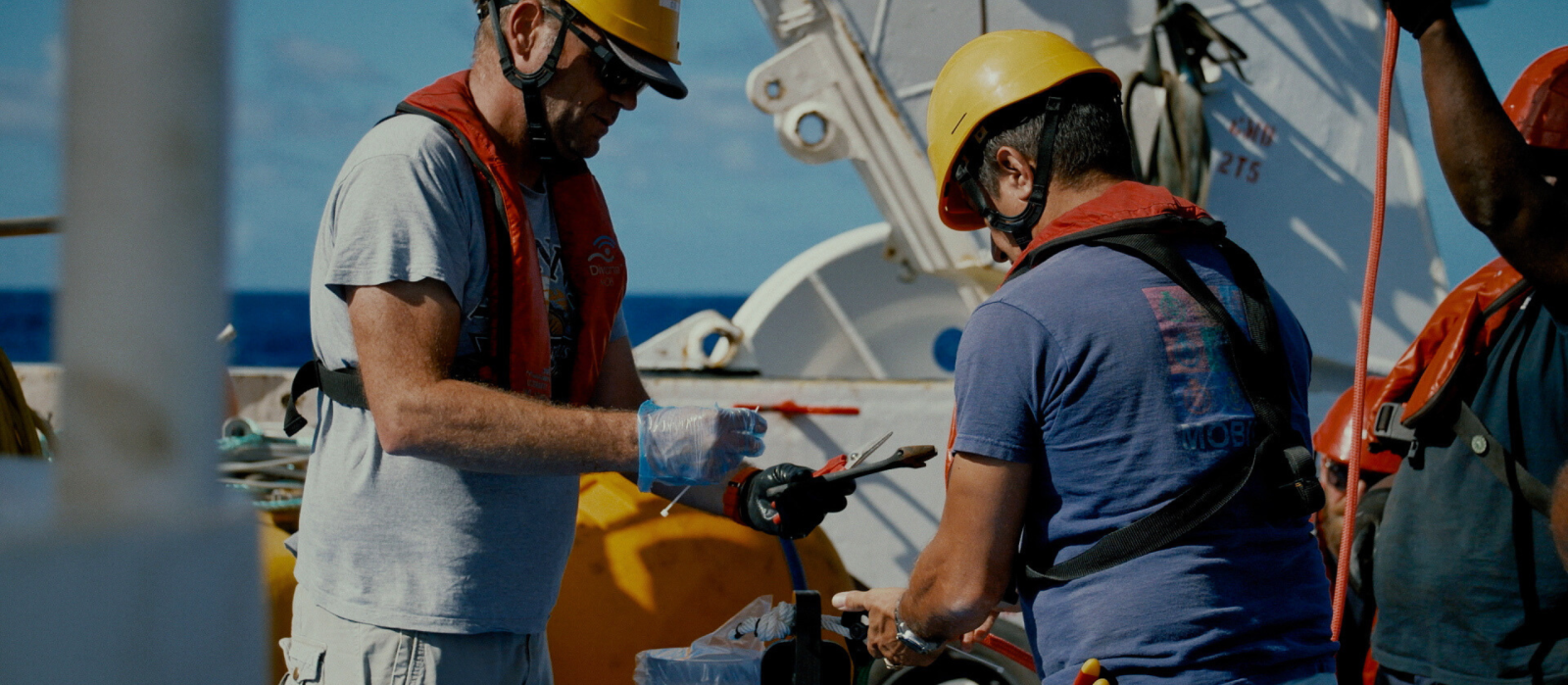 Chercheurs de l'IRD déployant des instruments de mesure depuis un bateau en mer